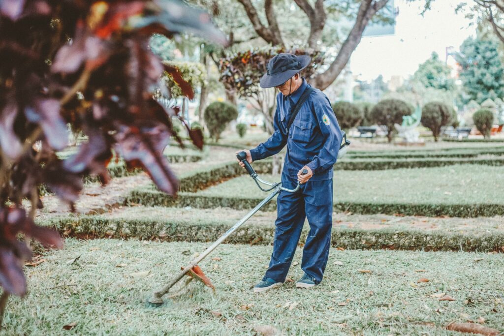 Photo of a man weed whacking a lawn